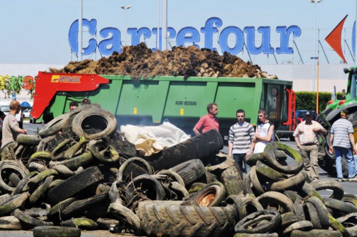 Γάλλοι αγρότες διαμαρτύρονται καίγοντας λάστιχα έξω από κατάστημα της Carrefour