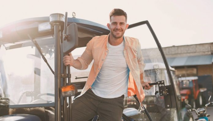 Male,Standing,By,The,Blue,Tractor